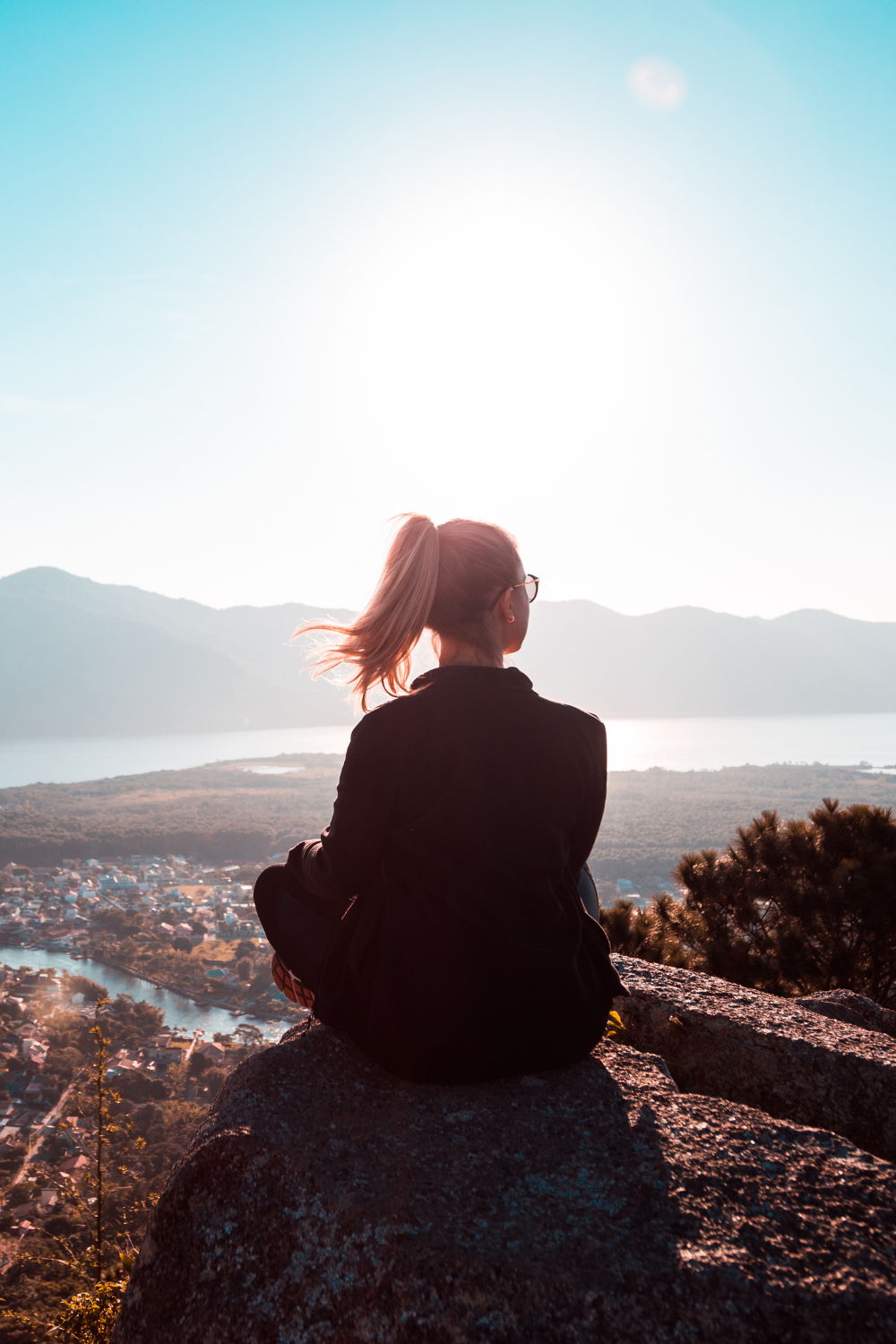 A confident individual standing at the edge of a mountain, symbolizing courage and fearlessness.